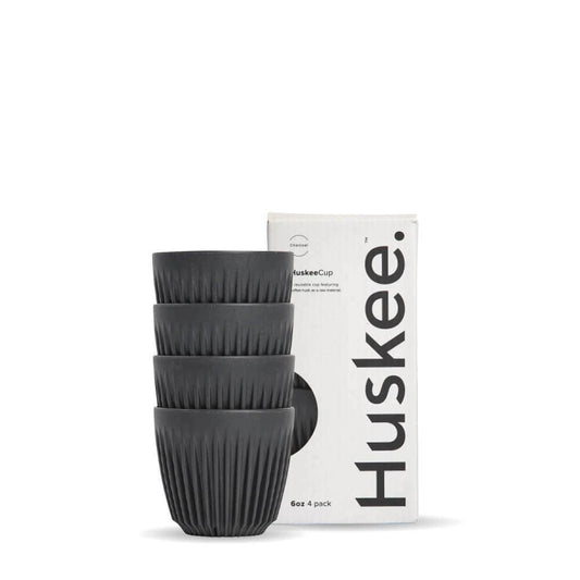 Pack of 4, 6oz Charcoal Huskee reusable coffee cups stacked in front of packaging box