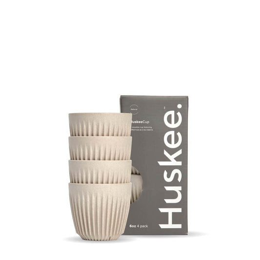 Pack of 4, 6oz Natural Huskee reusable coffee cups stacked in front of packaging box