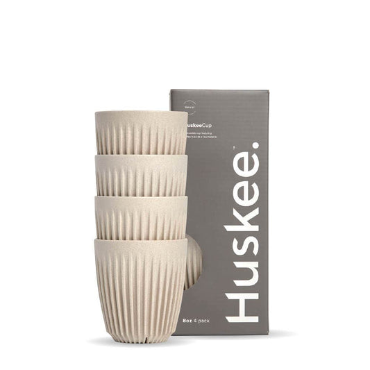 Pack of 4, 8oz Natural Huskee reusable coffee cups stacked in front of packaging box