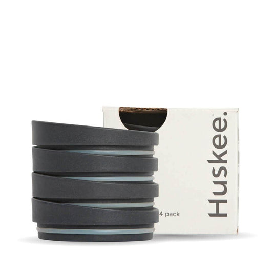 4-pack of Charcoal HuskeeCup Universal Lids in front of the packaging box
