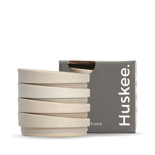 4-pack of Natural HuskeeCup Universal Lids in front of packaging box